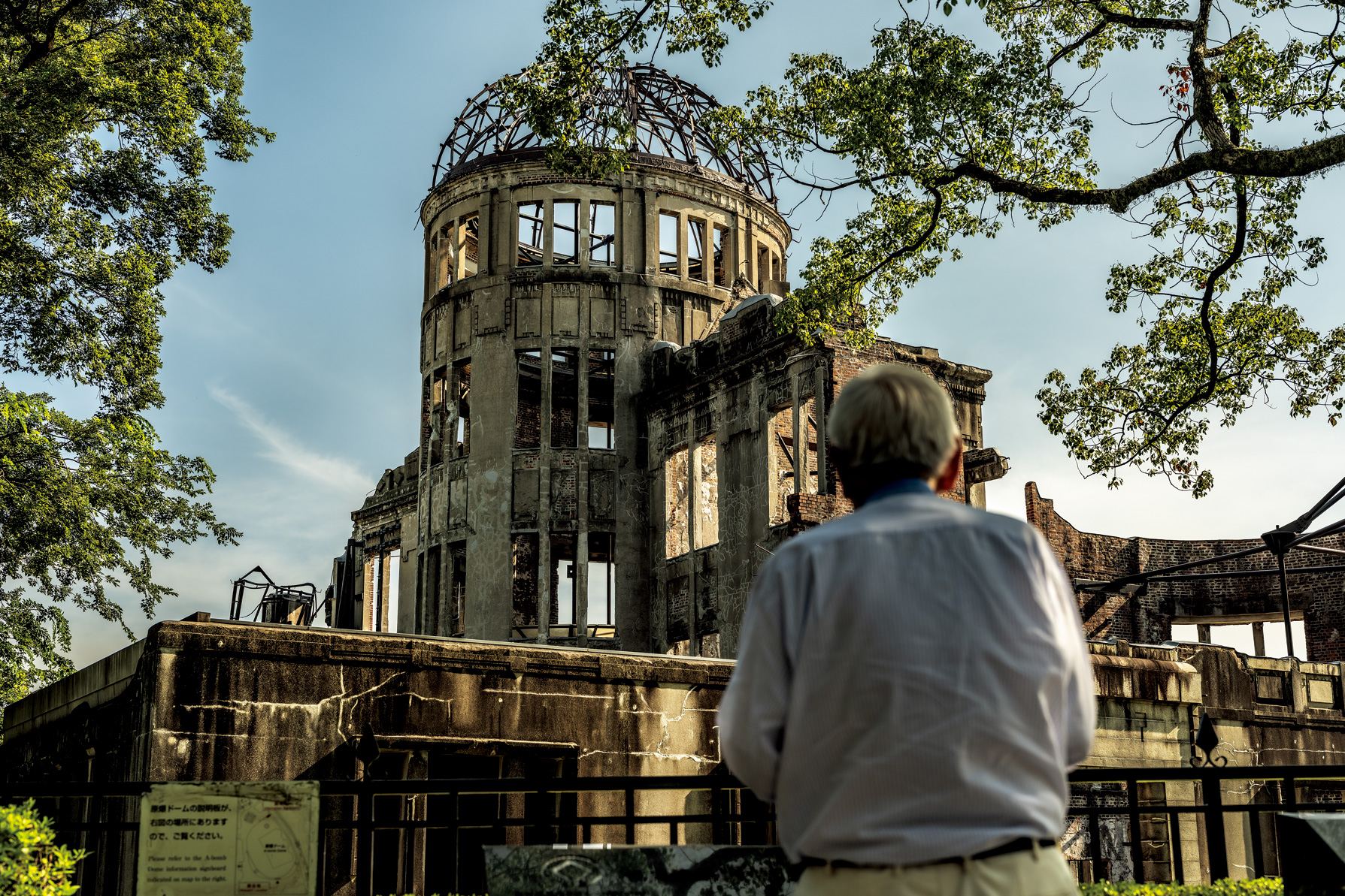 原爆ドームと、原爆ドームを見つめる田中さんの後ろ姿